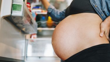 pregnant women looking in fridge