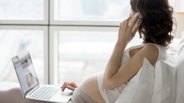 Pregnant woman on her phone and laptop