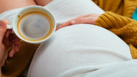 Pregnant woman holding coffee