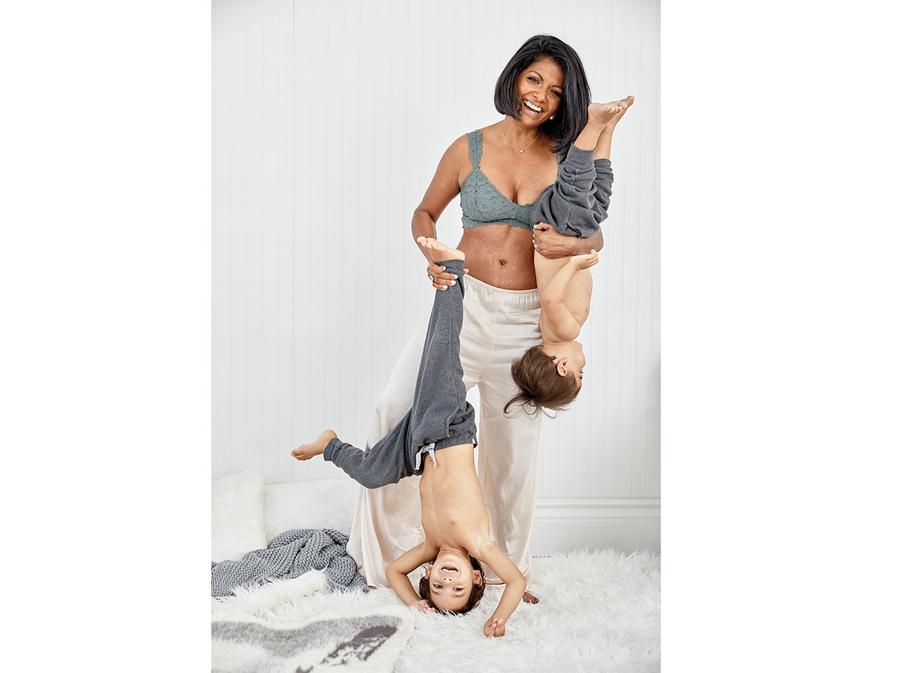 Anupa King showing of he ppostpartum belly why holding her kids upside down