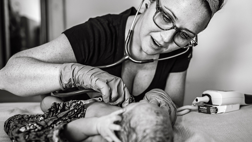 midwife checking newborns heartbeat
