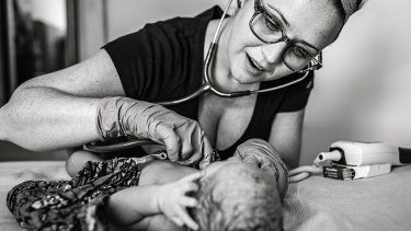 midwife checking newborns heartbeat