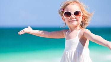 Little girl wearing sunglasses on the beach