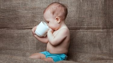 baby sipping out of a mug