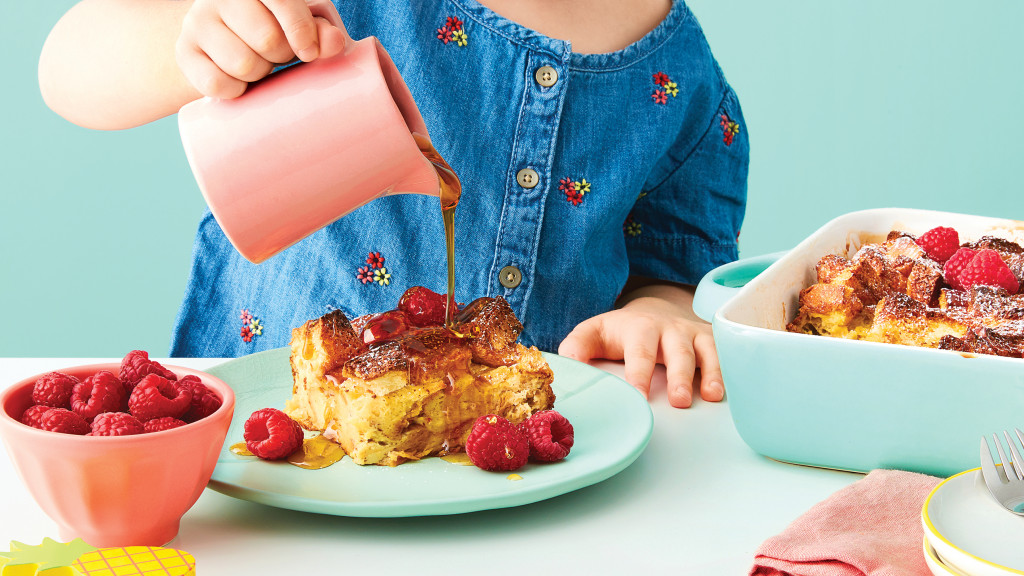 child pouring syrup on French toast