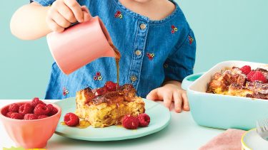 child pouring syrup on French toast