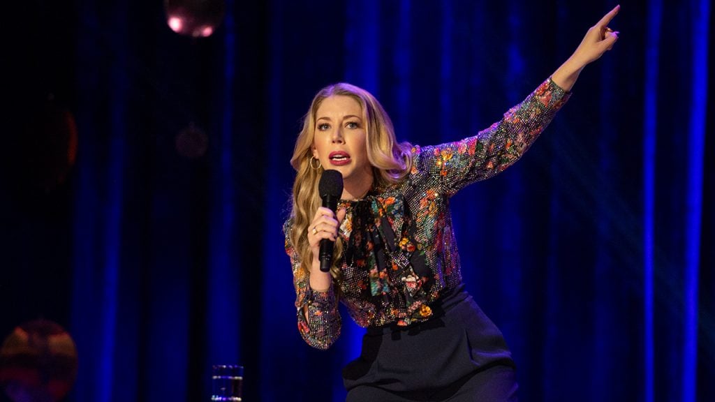 Promo image for Katherine Ryan: Glitter Room showing a woman doing stand up comedy