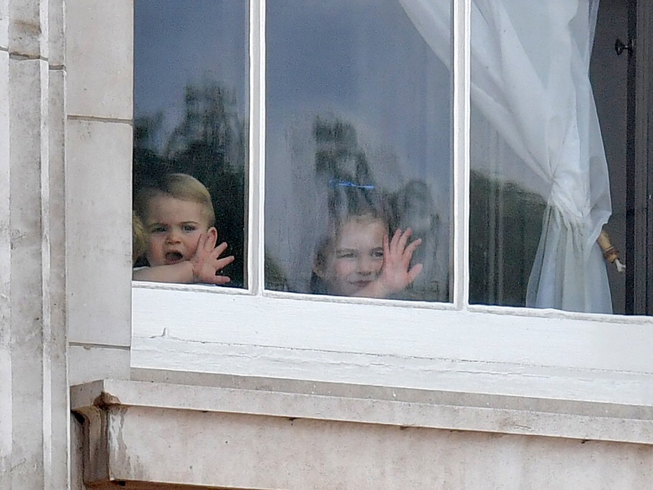 prince louis and princess charlotte waving in the window