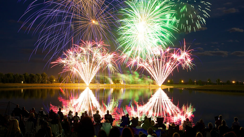 Fireworks explode above a lake