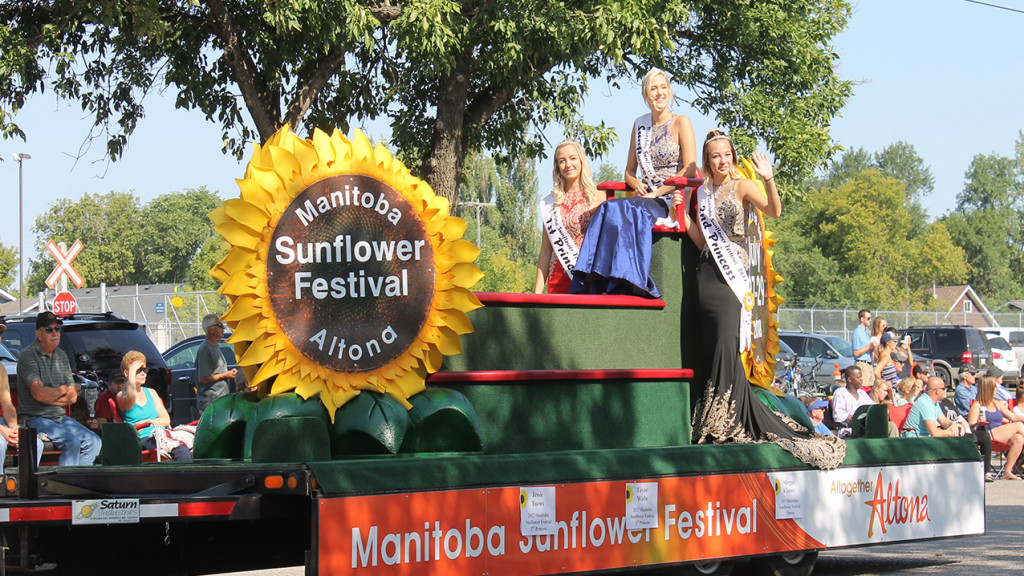 Girls wave on a sunflower parade float