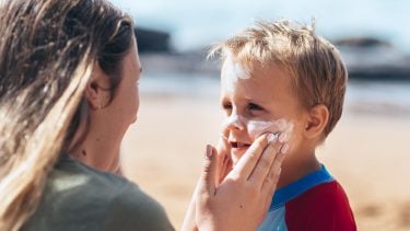 Mom putting sunscreen on her child's face