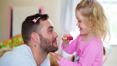 Daughter puts makeup on dad during play time
