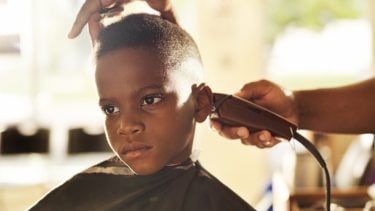 Young boy getting his hair cut at a barber shop