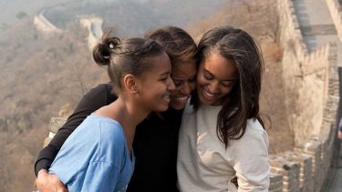 Michelle Obama hugging Malia and Sasha on the Great Wall of China