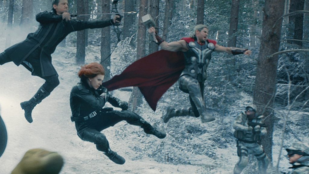 three super heroes jumping into a fight on a snowy landscape