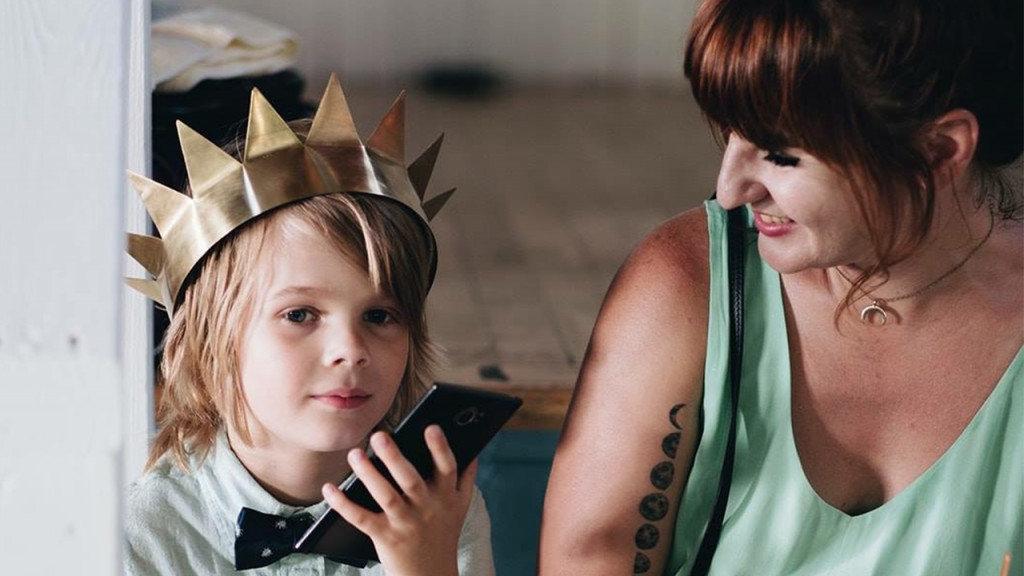 Mom and kid wearing crown sitting