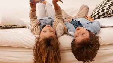 Kids lay on couch reading book