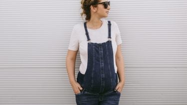 Second trimester: Fashionable pregnant woman in overalls