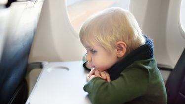 Lonely young boy sitting on airplane