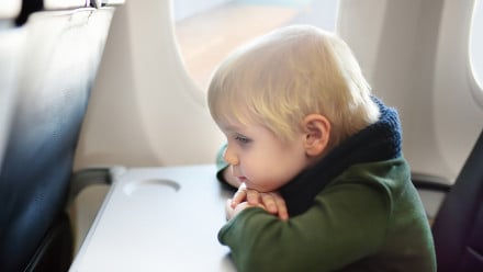 Lonely young boy sitting on airplane