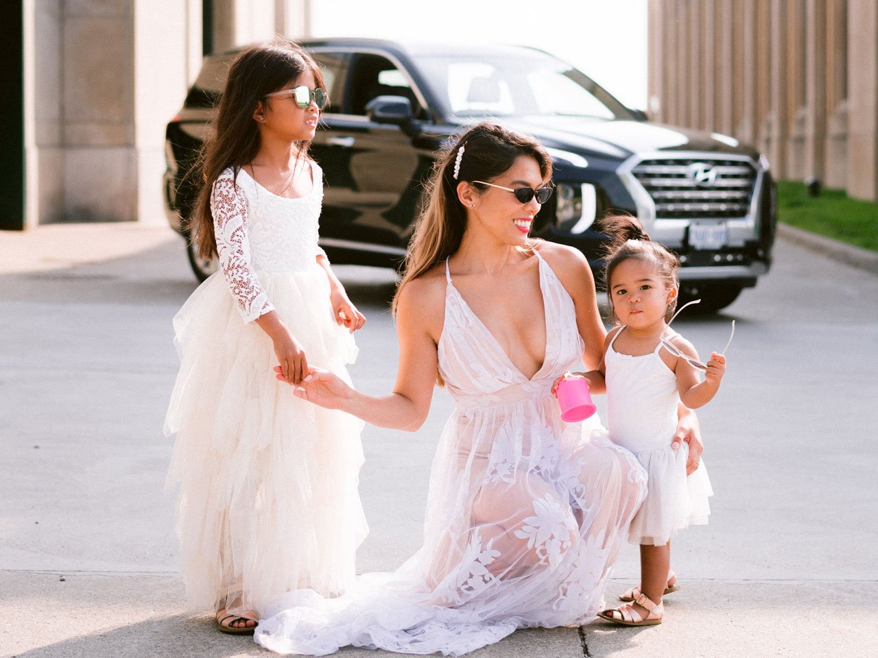 Trisha Enriquez with her daughters in front of Hyundai Palisade