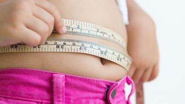 a young girl with a measuring tape around her stomach