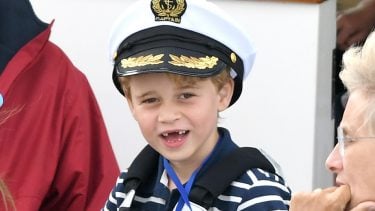 prince george smiling in a captain's hat missing middle teeth