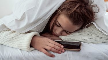 Teen girl sleeping with phone