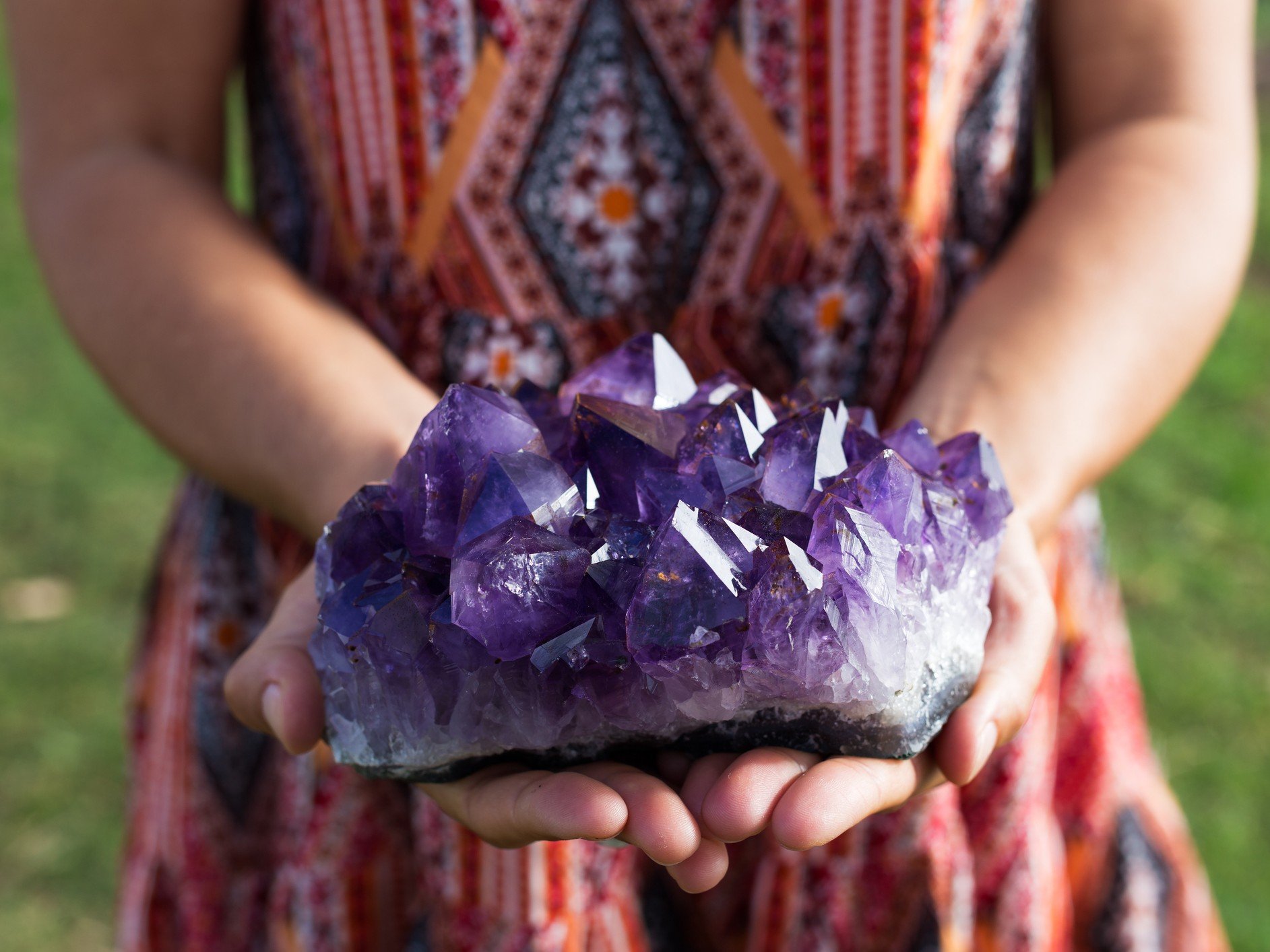 Birthstones by month: Girl holding an amethyst rock