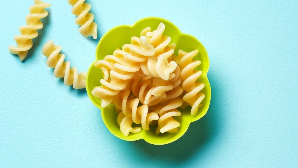 Cooked fusilli pasta in a lime-green flower-shaped cup
