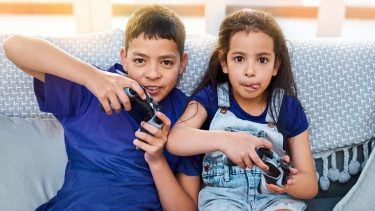 boy and girl on couch playing video games