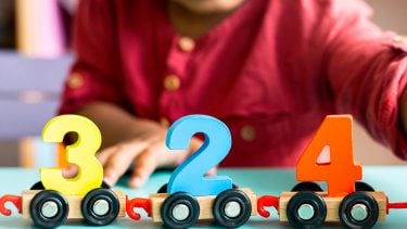 A child plays with cars with numbers attached.