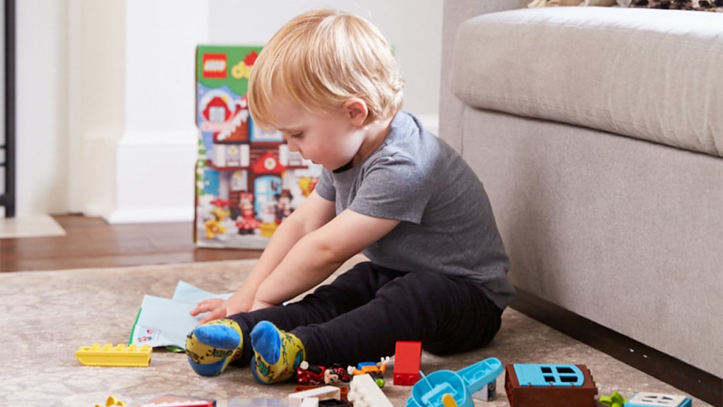 Moms in the Middle parenting podcast host Evanka Osmak and her son George play with LEGO Duplo on the living room floor