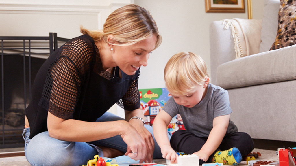Moms in the Middle parenting podcast host Evanka Osmak and her son George play with LEGO Duplo on the living room floor