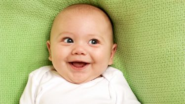 Smiling baby on a green blanket