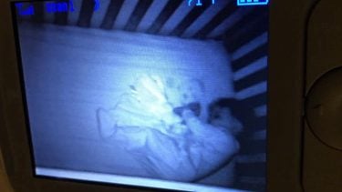 baby monitor screen showing a baby sleeping next to what looks like a ghost baby