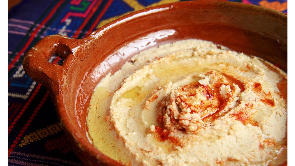 Hummus in an orange ceramic pot