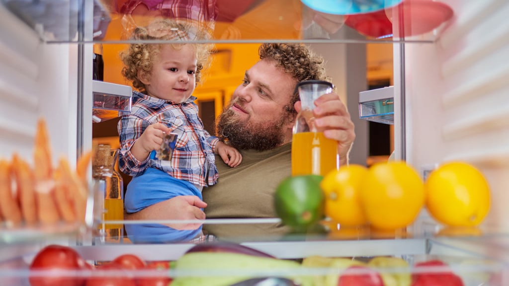 Dad in fridge looking for a snack for toddler