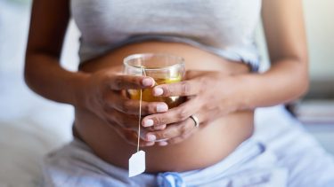 Natural heartburn remedies: Pregnant woman holding a cup of tea