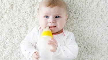 Baby with a bottle looking perplexed