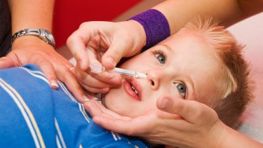 A child gets the nasal mist vaccine.
