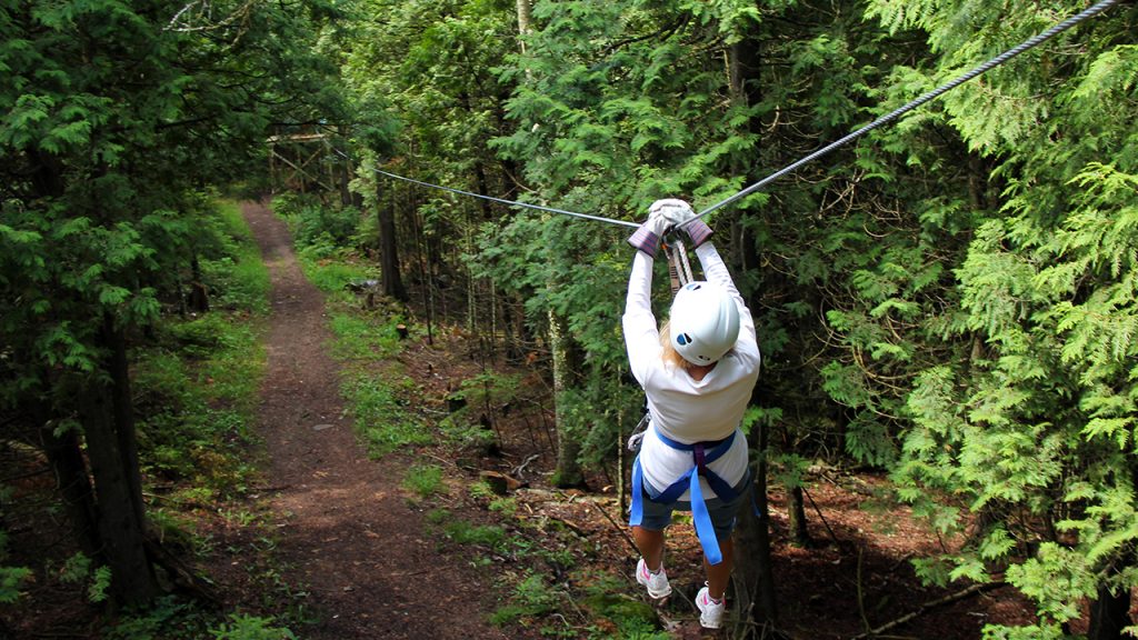 Adult zip-lining in forest