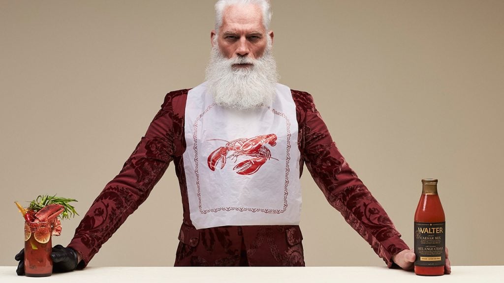 Fashion Santa holding a caesar and a bottle of caesar mix