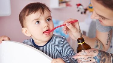 Mother feeds child a spoon of medication but Benadryl for kids isn't safe
