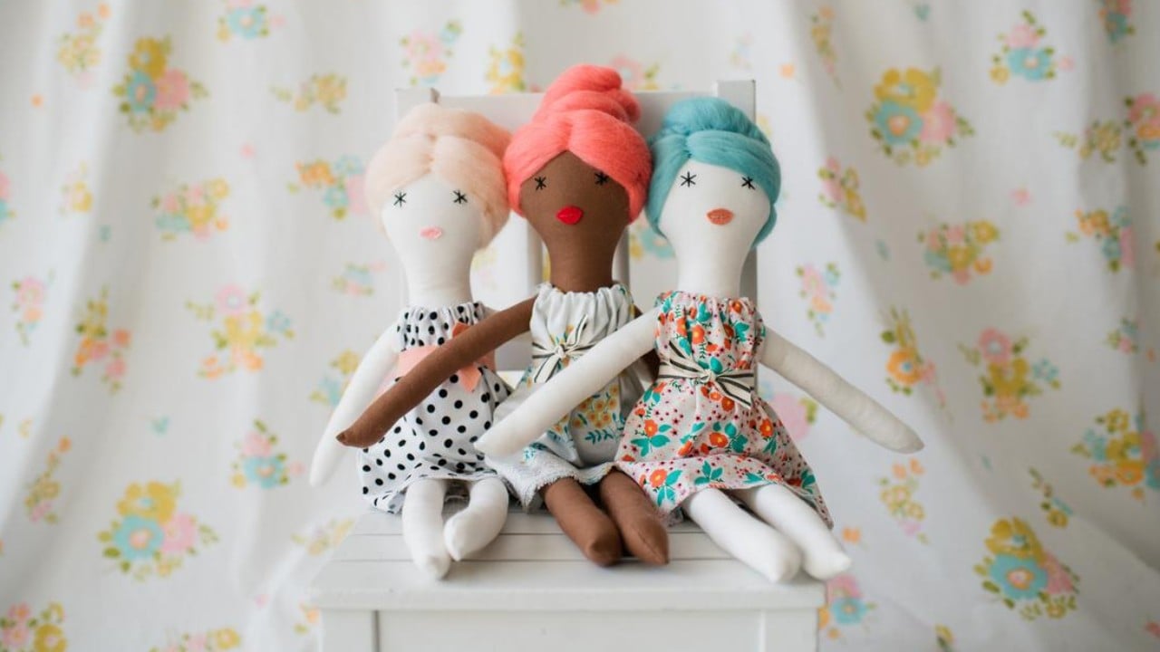 three dolls sitting on a table 