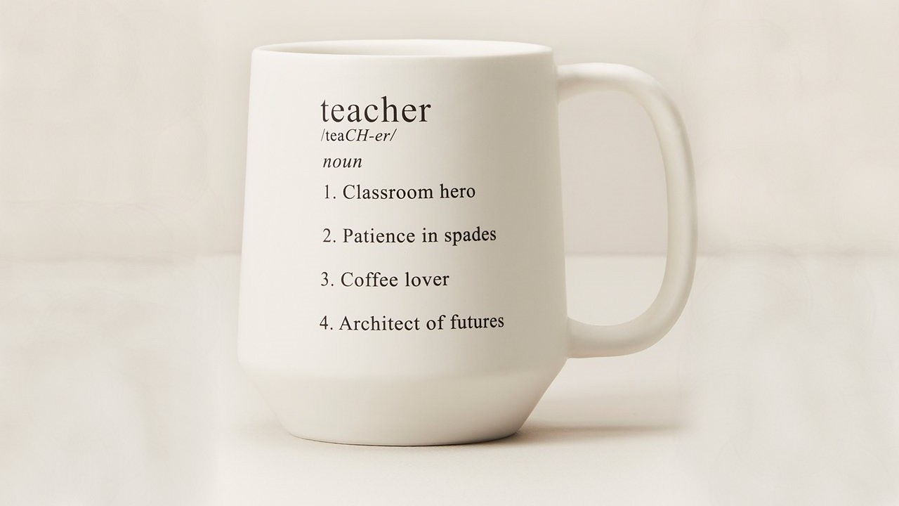 white mug with dictionary definition of teacher written on it