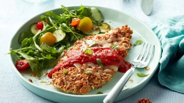 plate of baked chicken parmesan with side salad