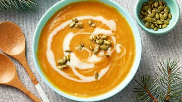 bowl of curried butternut squash soup with coconut milk drizzle