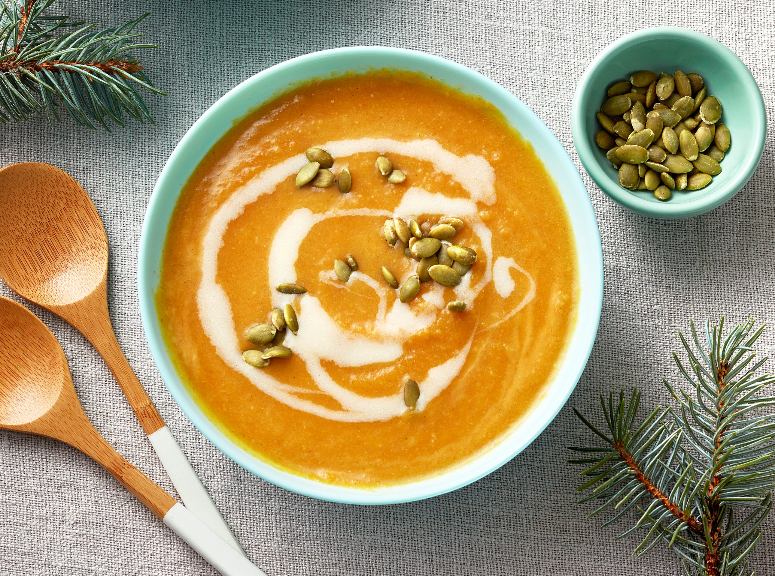 bowl of curried butternut squash soup with coconut milk drizzle