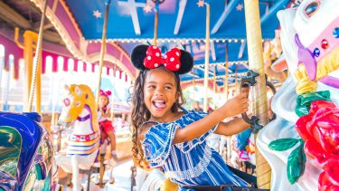 young girl on carousel smiling